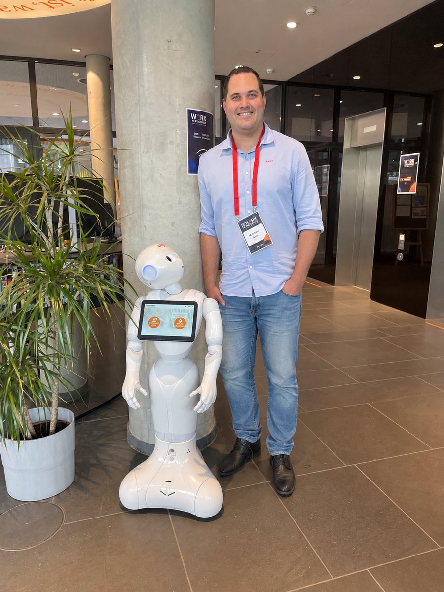 Christian Tuschner neben dem humanoiden Roboter Pepper auf der Konferenz Work in Progress